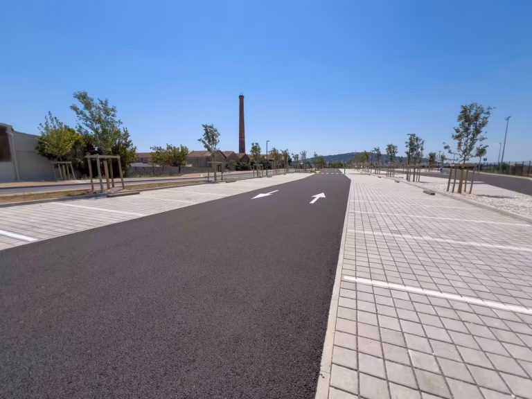 Allée du parking relais Voie de contournement Nord, avec la cheminée du Chai des Moulins en arrière-plan
