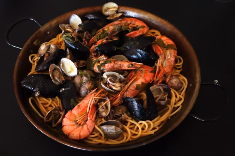 Spaghettis aux fruits de mer dans une poele avec moules palourdes et crevettes