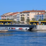 Deux bus jaunes sur un pont au-dessus du canal à Sète