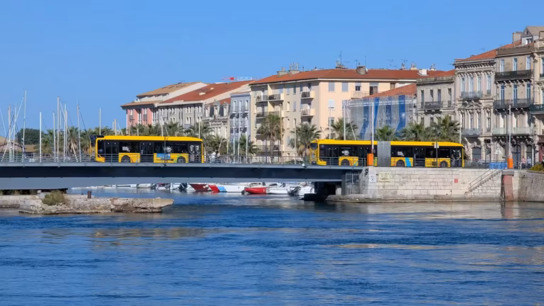 Deux bus jaunes sur un pont au-dessus du canal à Sète