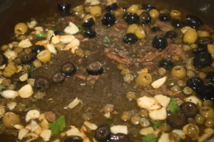 Ail, anchois, câpres et olives dans l'huile d'olive chaude
