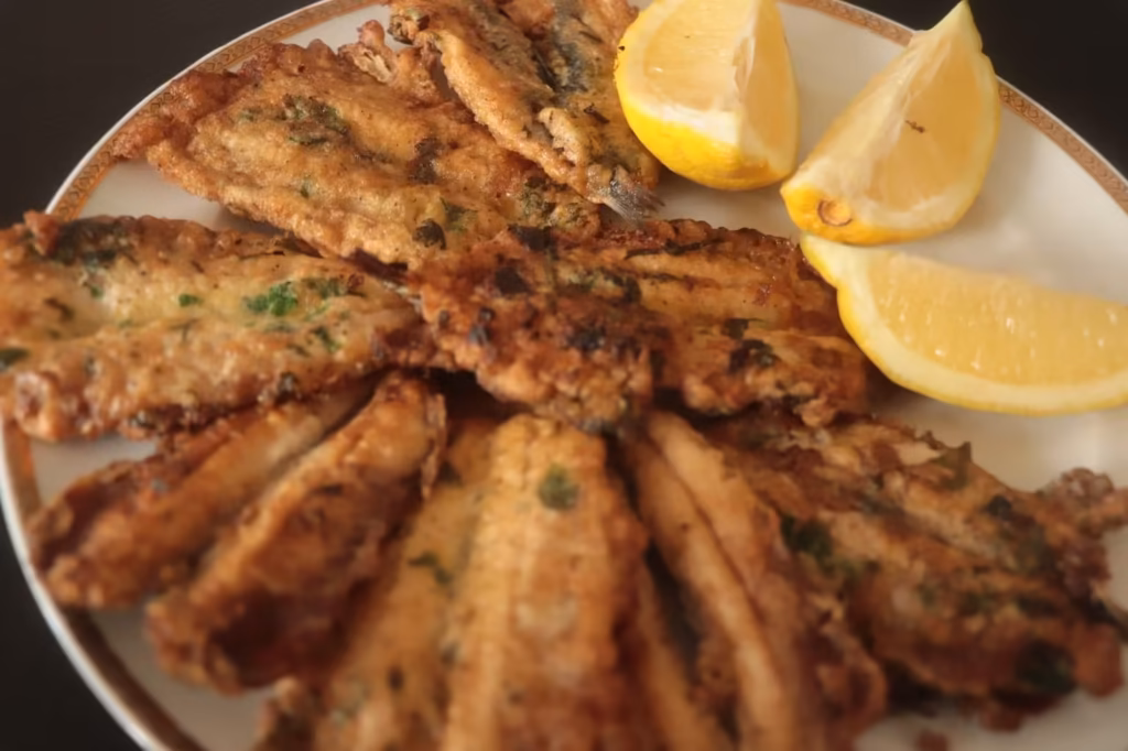 Anchois à l'œuf persillé dorés, servis avec des quartiers de citron