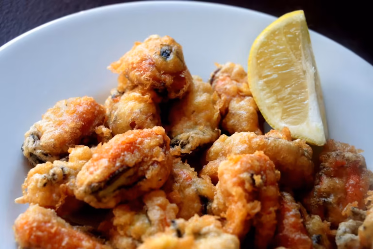 Assiette de beignets de moules dorés avec un quartier de citron