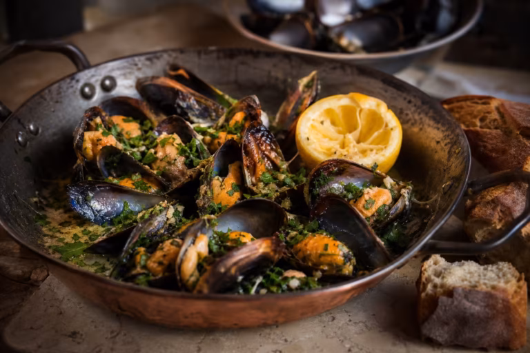 Brasucade de moules au gingembre et à l'ail dans une poêle en cuivre