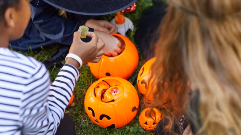 Enfants récoltant des bonbons dans des citrouilles d’Halloween