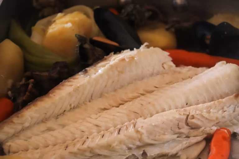 Poisson poché ouvert en filets, moules et légumes de l'eau sel