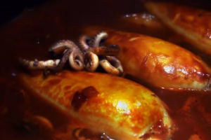 Encornets farcis en train de mijoter dans la sauce tomate