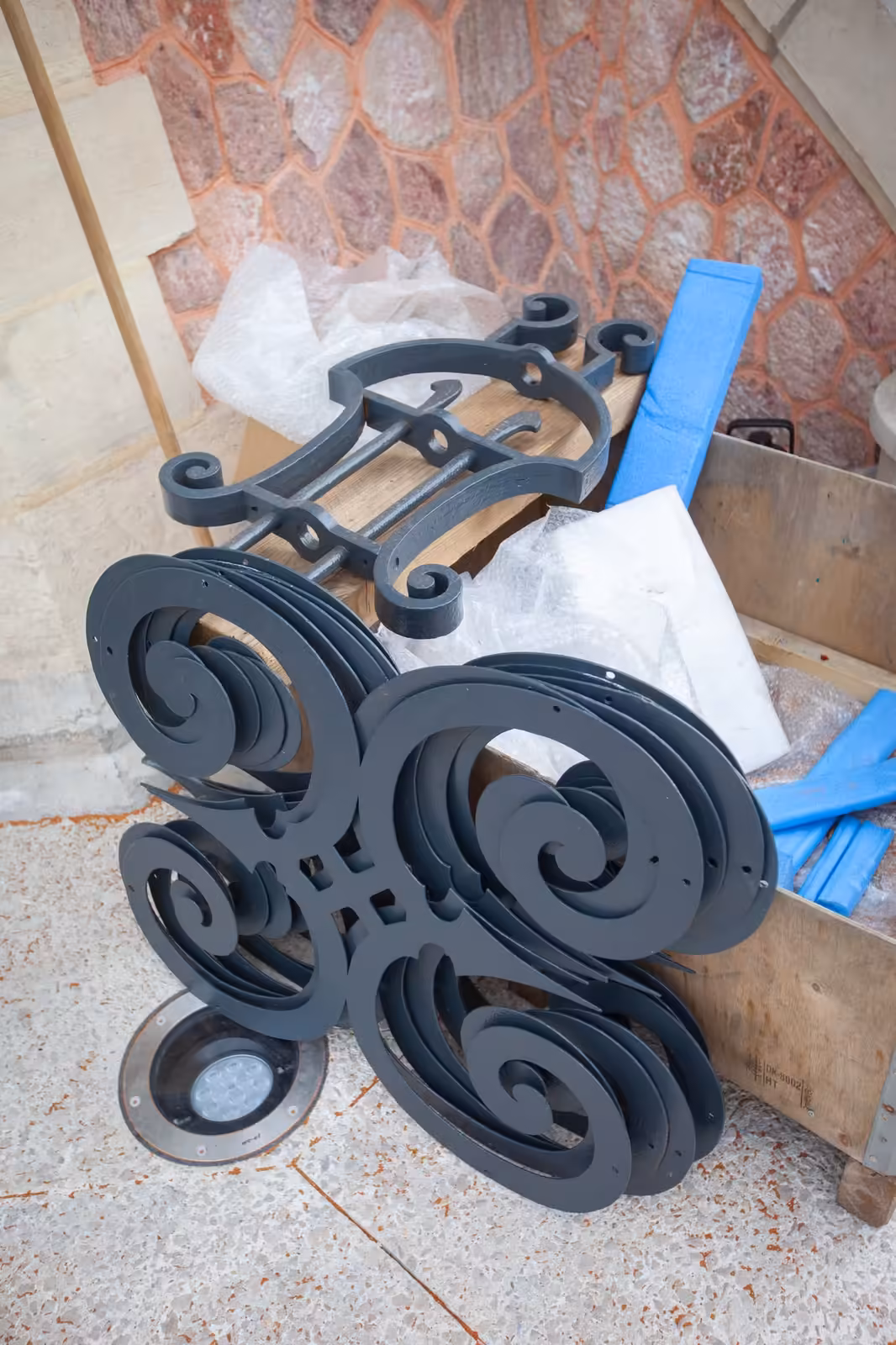 Volutes en fer forgé du kiosque Franke restaurées et posées au sol avant leur remontage