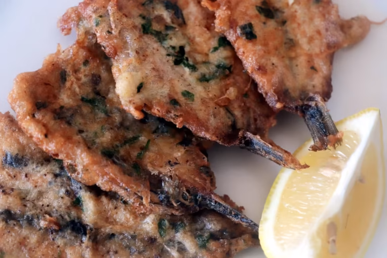 Gros plan sur les anchois persillés et un quartier de citron