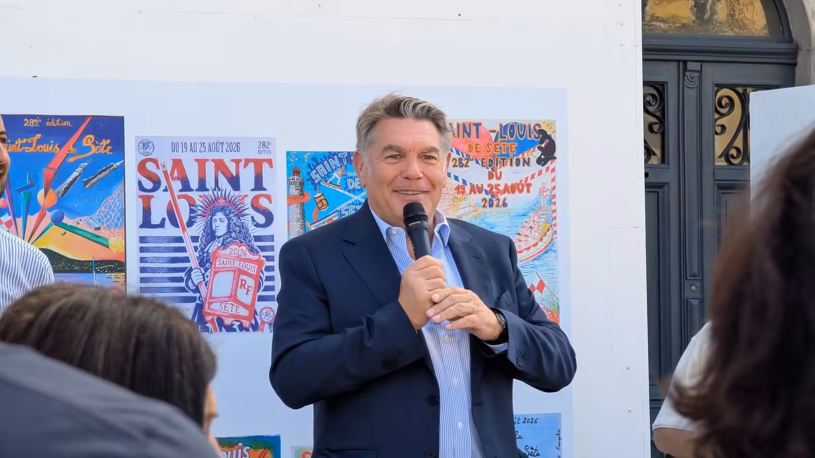Hervé Marquès au micro devant les affiches du concours de la Saint-Louis 2026