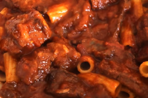Gros plan sur la sauce rouge brun de la macaronade et ses rigatoni