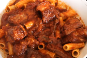 Rigatoni mélangés à la sauce et aux morceaux de viande de la macaronade