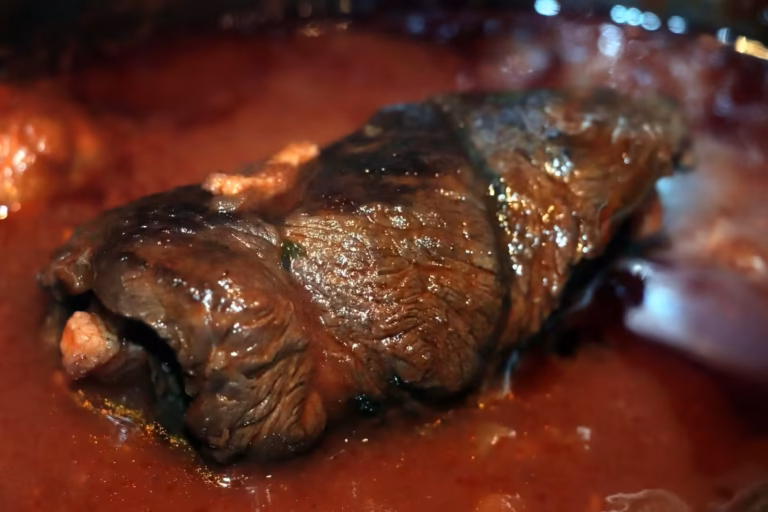 Gros plan d'une brageole, paupiette de paleron roulée, mijotée dans la sauce tomate