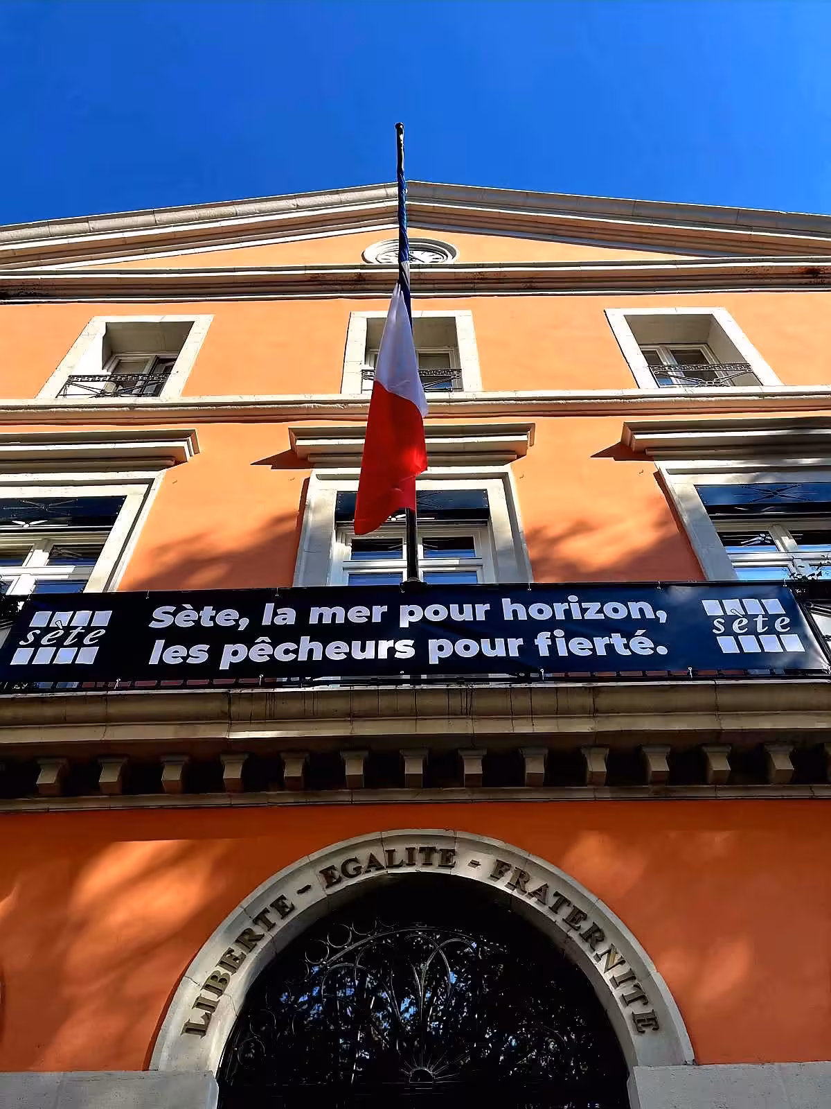 Banderole « Sète, la mer pour horizon, les pêcheurs pour fierté » déployée sur la façade de la mairie de Sète en septembre 2026