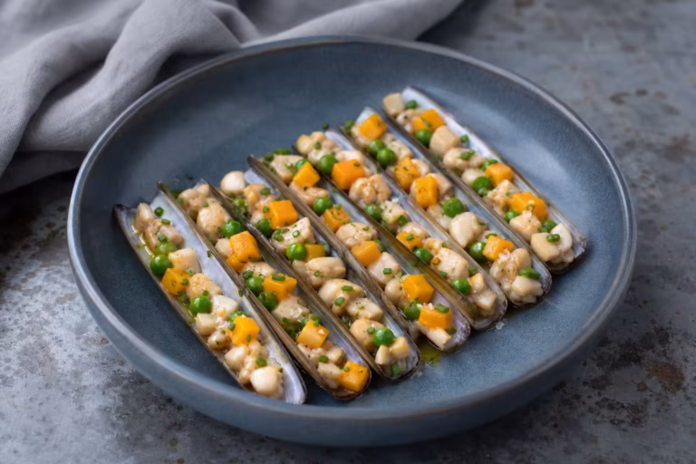 Mosaique de couteaux a la mangue et aux petits pois servie en coquille