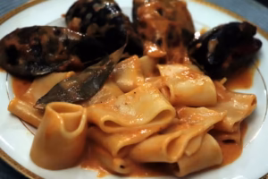 Moules farcies servies avec des pâtes et leur sauce