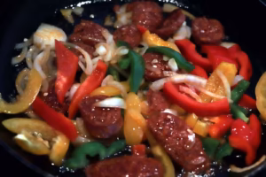 Garniture de poivrons, oignon et chorizo en train de revenir à la poêle