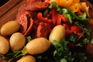 Chorizo en rondelles, poivrons taillés et pommes de terre grenaille sur une planche