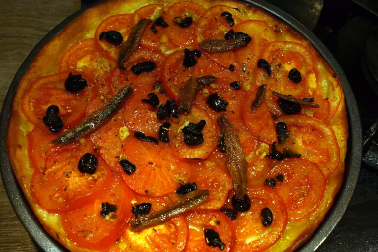 Pizza sétoise entière aux tomates, anchois et olives noires cuite