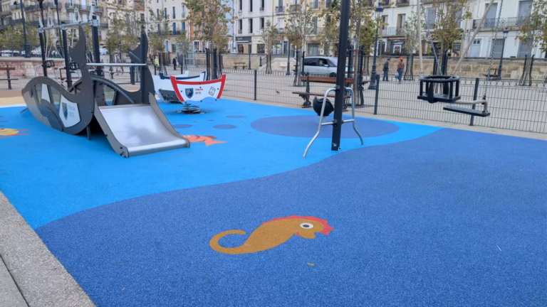 Aire de jeux de la place Aristide Briand : sol bleu orné d'un hippocampe, toboggan et jeux en forme de barques