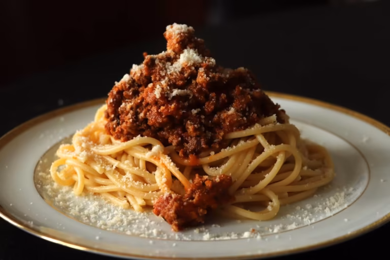 Spaghettis au ragù bolognaise servis à l'assiette avec du parmesan râpé