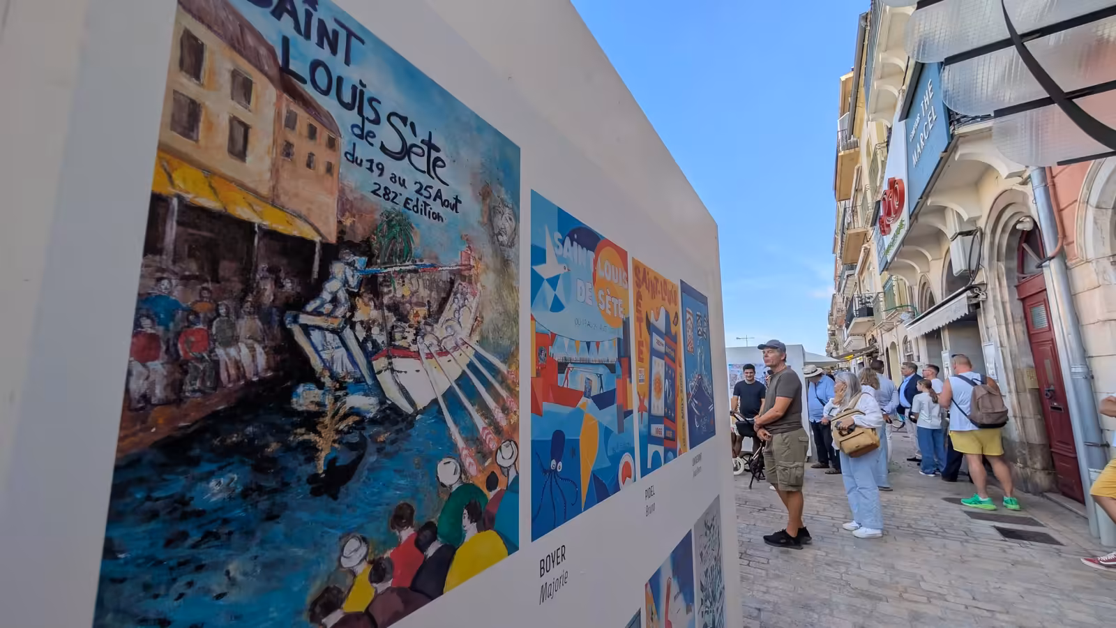 Visiteurs devant les affiches du concours de la Saint-Louis 2026 exposées quai Suquet
