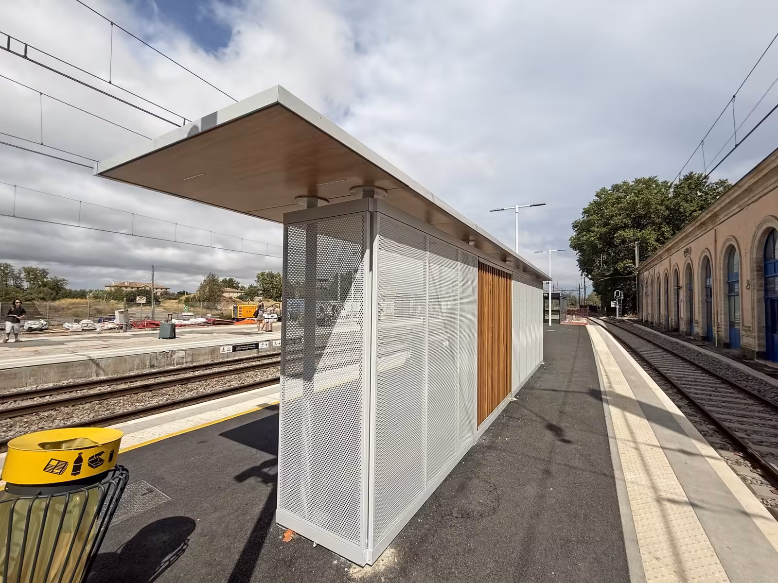 Nouvel abri sur un quai de la gare d'Agde, aux parois en métal perforé et au plafond en bois