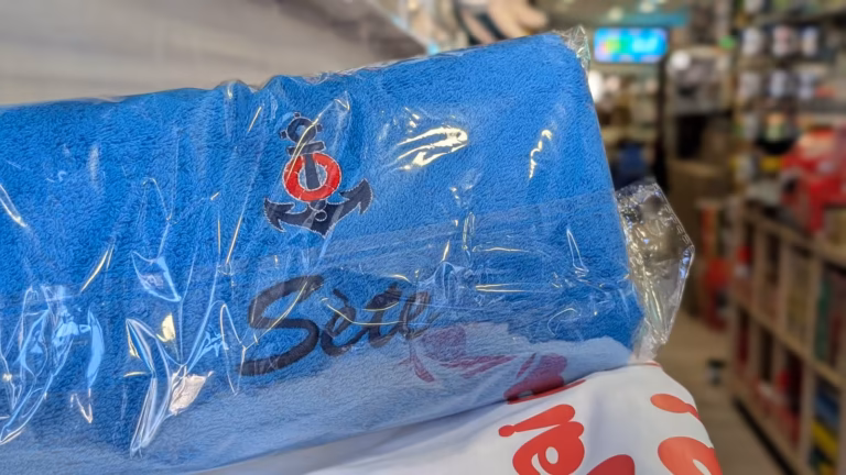 Serviette bleue brodée d'une ancre et du nom de Sète