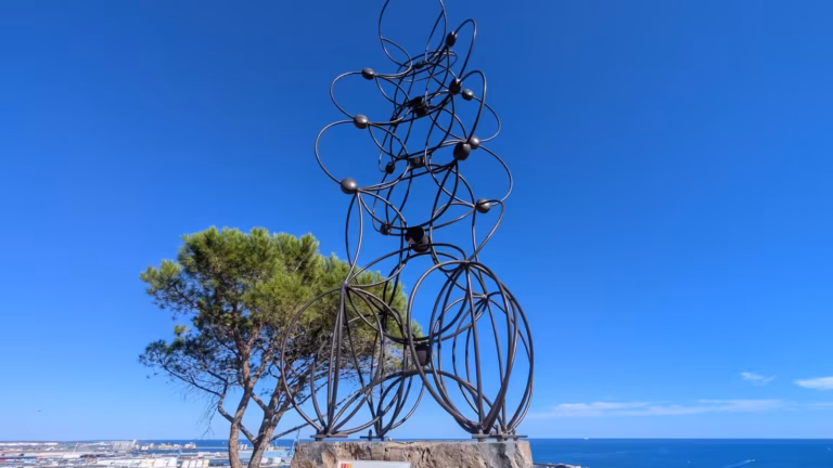 L'Arbre de Vie, structure métallique en anneaux, vu de loin avec un pin à côté