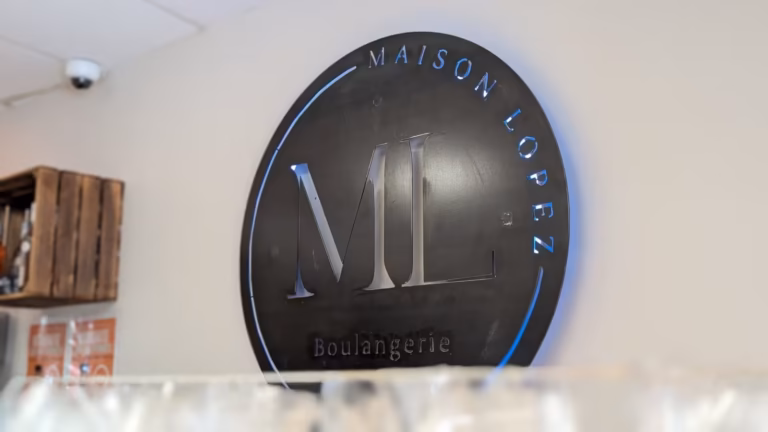 Logo « Maison Lopez, Boulangerie » au mur de la boutique