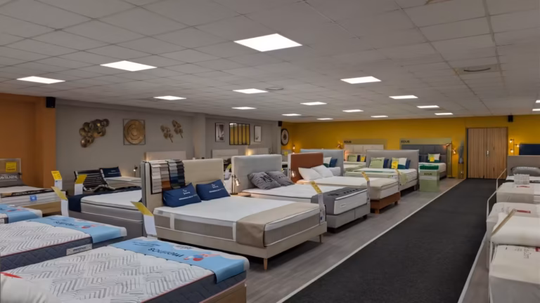 Allée de lits et de matelas d'exposition dans le magasin Méridionale de la Literie à Sète