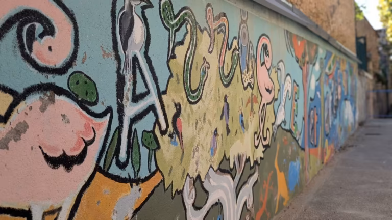 Détail de la fresque murale aux personnages et lettres colorés