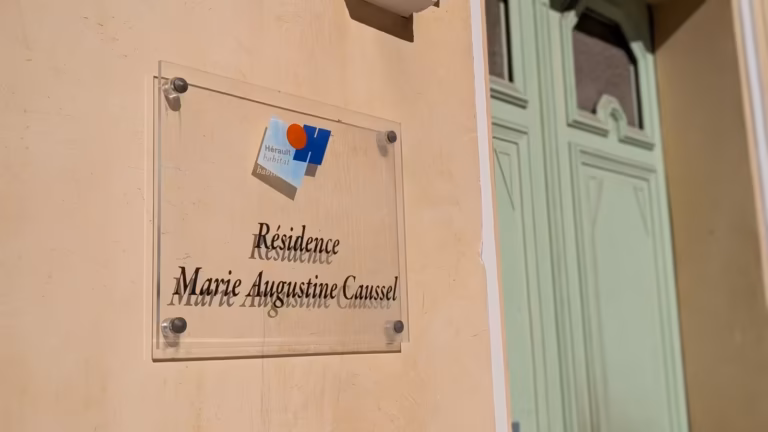 Plaque « Résidence Marie Augustine Coussel » près d'une porte verte