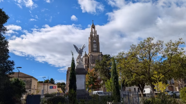 Clocher de l'église et monument aux morts vus depuis l'espace sportif