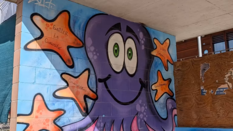 Fresque d'une pieuvre violette et d'étoiles de mer sur le mur de l'école