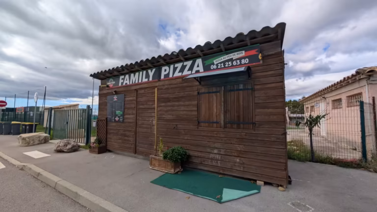 Family Pizza vu de côté, tapis vert devant le comptoir