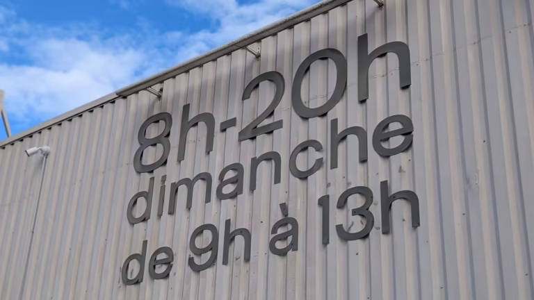 Inscription peinte des jours d'ouverture sur le mur du Carrefour contact
