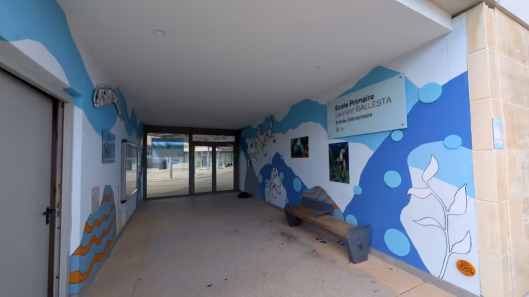 Préau de l'école décoré de vagues bleues et de photos marines