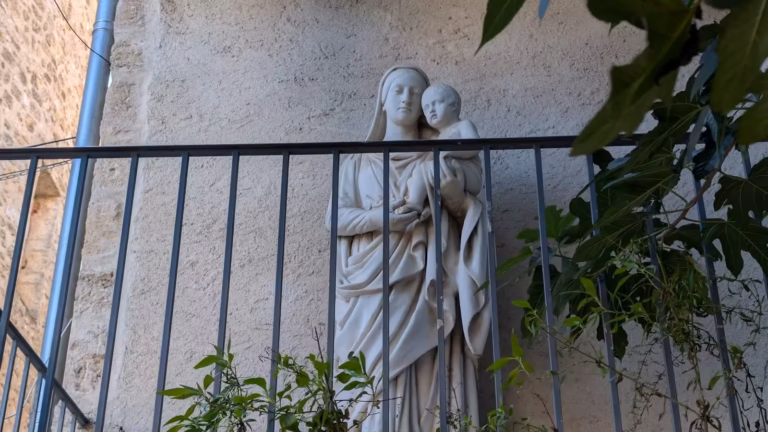 Statue de la Vierge à l'Enfant derrière une grille