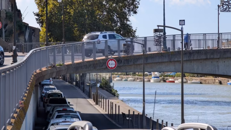 Voitures garées en bord d'Hérault sous le pont, parking de la Calade