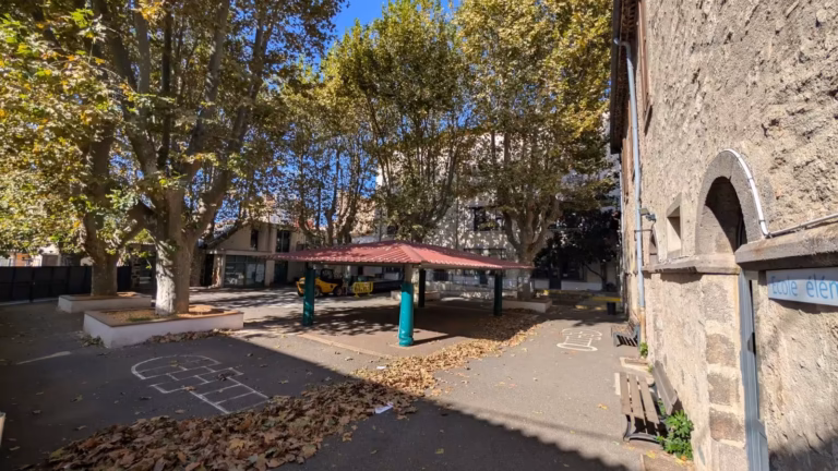 Cour arborée de l'école Jules Ferry et bâtiment en pierre