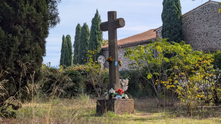 Croix de pierre fleurie dans le jardin de l'église Saint-Benoît