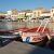 Barques rouges et blanches amarrées devant les façades du port de Mèze