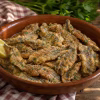 Anchois à l'œuf persillé dorés à la poêle dans un plat en terre cuite