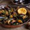 Brasucade de moules au gingembre et à l'ail dans une poêle en cuivre