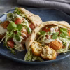 Croquettes de daurade et pois chiches garnies dans des pains pita avec sauce au yaourt