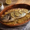 Daurade au four sur lit de pommes de terre et rondelles de citron