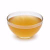 Bol de bouillon de légumes doré translucide sur fond blanc