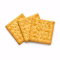Trois crackers salés dorés posés en éventail sur fond blanc