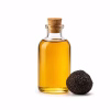 Flacon d'huile de truffe et truffe noire entière sur fond blanc